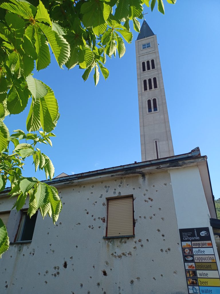 Bullet spattered Campanile café with Mostar Peace Bell Tower behind