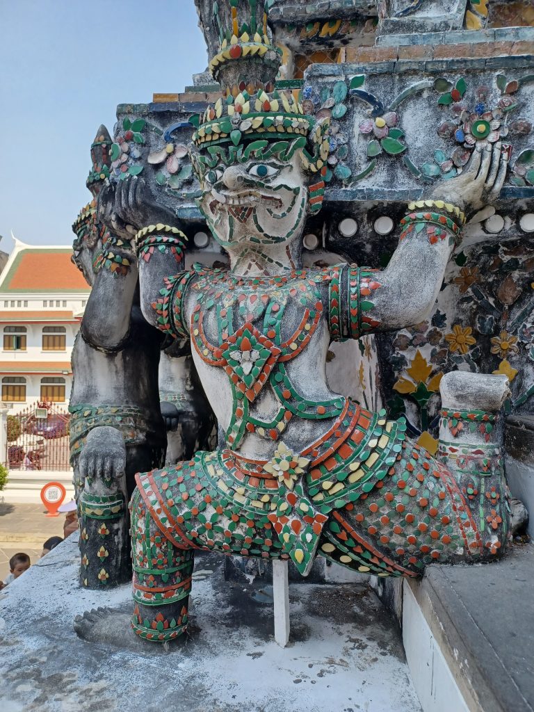 Mythical warrior holding up the prang, Wat Arun	