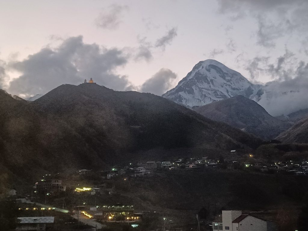 Sunset over Kazbegi mountain and Gergeti Trinity Church
