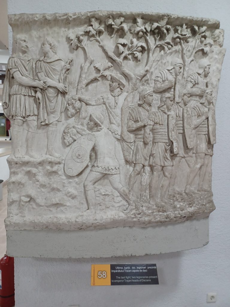 The Last fight: Two legionnaires present to Emperor Trajan heads of Dacians